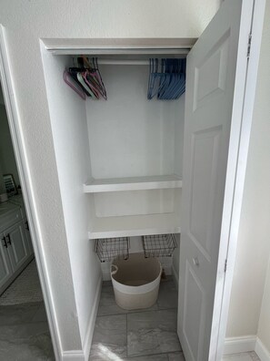 A small, enclosed closet with shelves and a storage bin. - Cozy 3-bedroom home near Warm Mineral Springs, mayakka river, and gulf beaches (North Port)