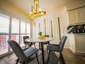 A dining area with a round table, four chairs, a chandelier, and a kitchen with cabinets. - 3-bedroom DUPLEX apartment in a serene environment Brampton, Canada (Brampton)