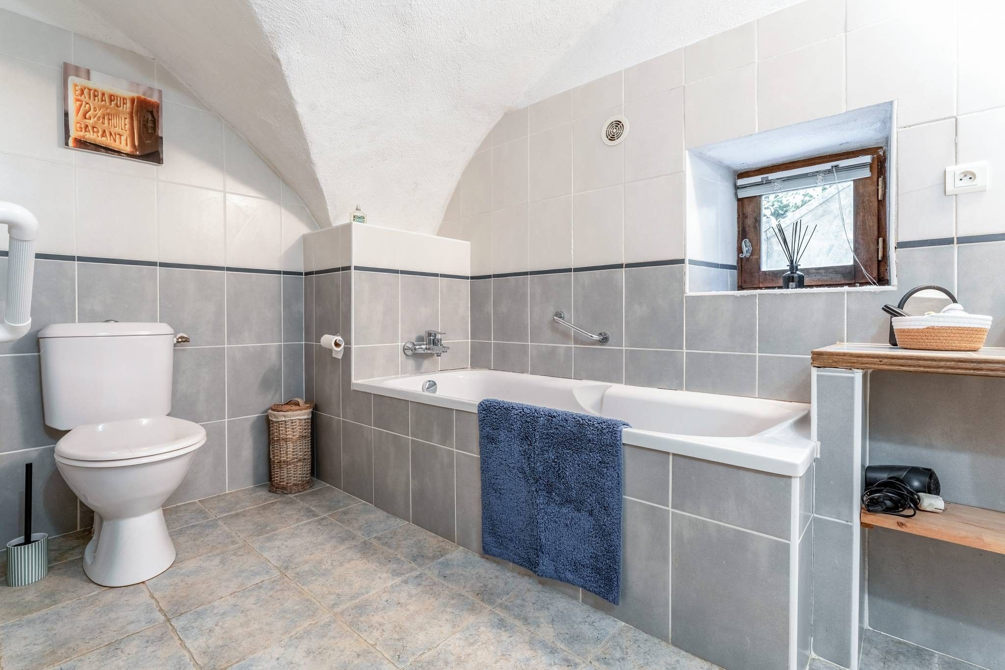 Een badkamer met toilet, bad en wastafel.