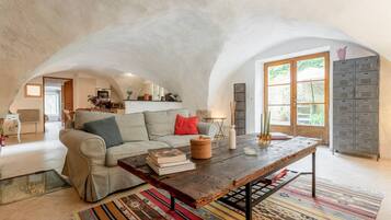A cozy living room with a sofa, a coffee table, and a patterned rug.