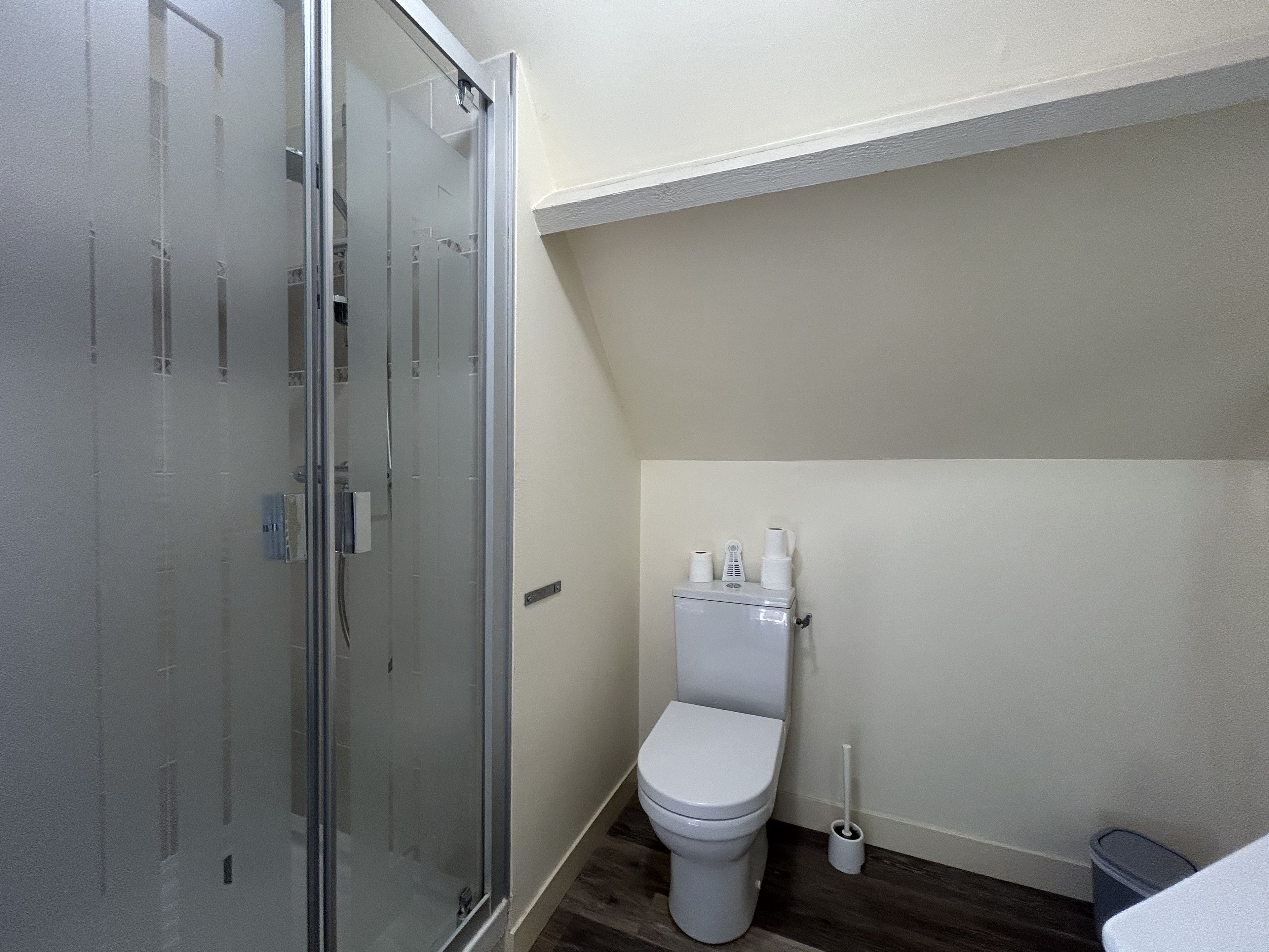 Une salle de bain avec une douche à parois de verre, des toilettes et un bidet.