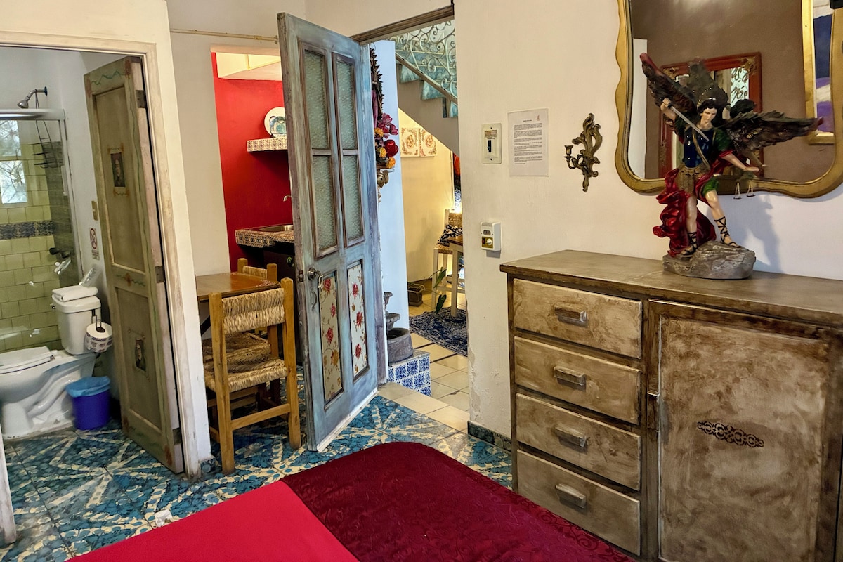 Een kamer met een badkamer, een eethoek en een spiegel met decoratief figuur.