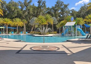 A swimming pool with a water slide and a children's play area. - Gated 4BR Oasis | Private Pool & Spa Near Disney (Kissimmee)