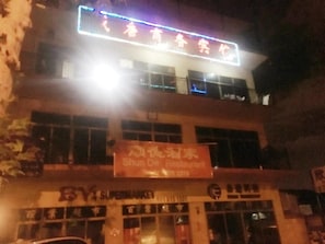 A building with a neon sign and a restaurant sign. - Shengtang Business Hotel (Johannesburg)