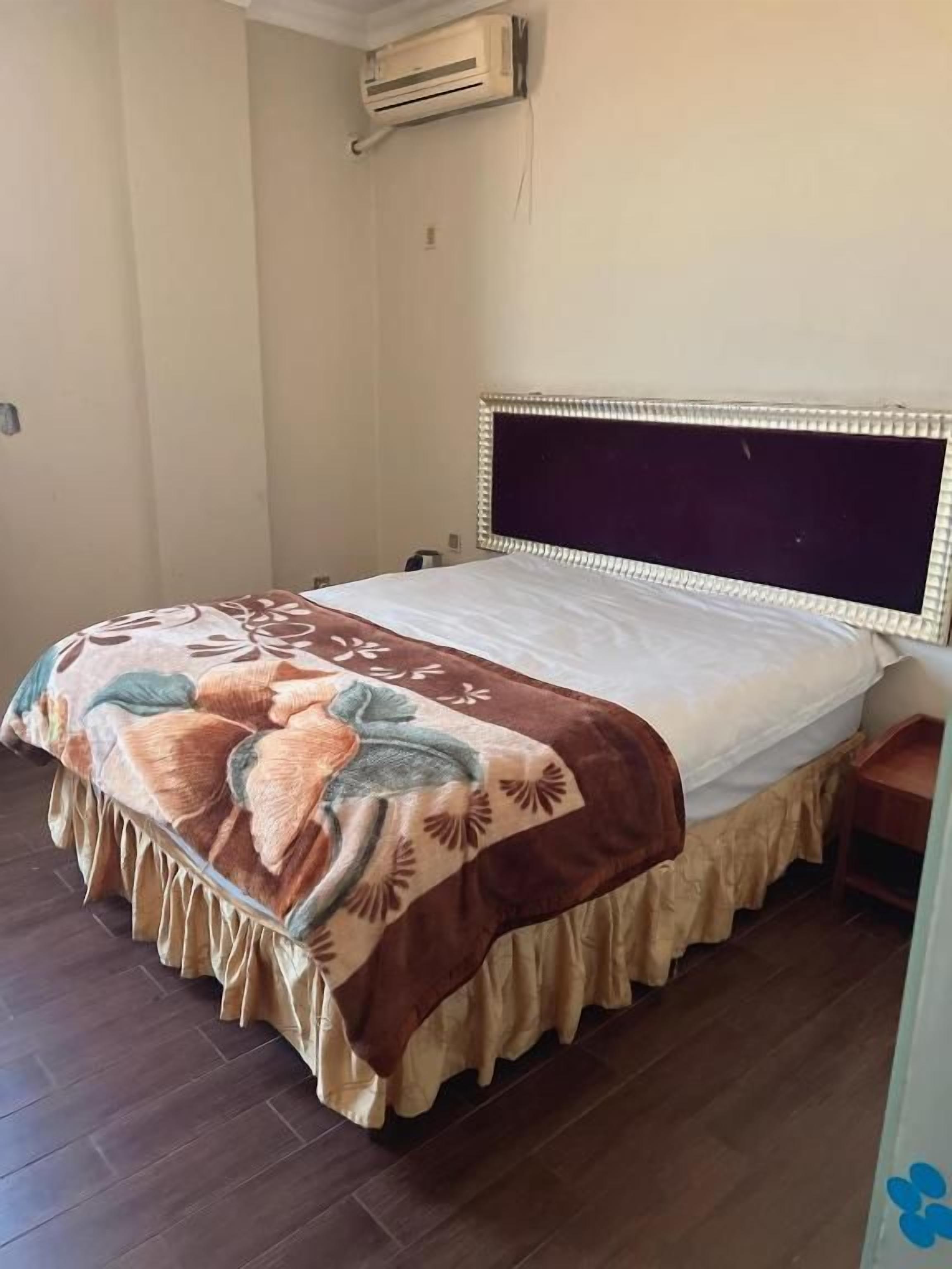 A bed with a decorative headboard and a patterned bedspread.