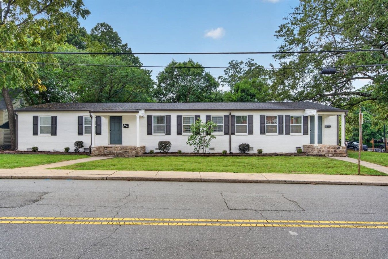 A single-story house with a front porch, a small front yard, and a street view.