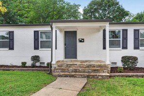 A two-story house with a front porch, a stone staircase, and a mailbox. - Crown Downtown | Close to Uptown & Local Dining (Charlotte)