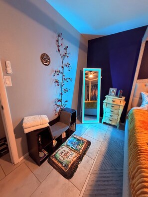 A bedroom with a bed, a chair, a dresser, a mirror, and a small table with a decorative item. - Charming 2-bedroom apartment with AC in lively Phoenix (Phoenix)