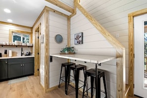 A kitchen with a white countertop, wooden beams, a clock, and a plant. - 3 Cabin Rental on Private Farm, 15 mins from Chatt (Chattanooga)