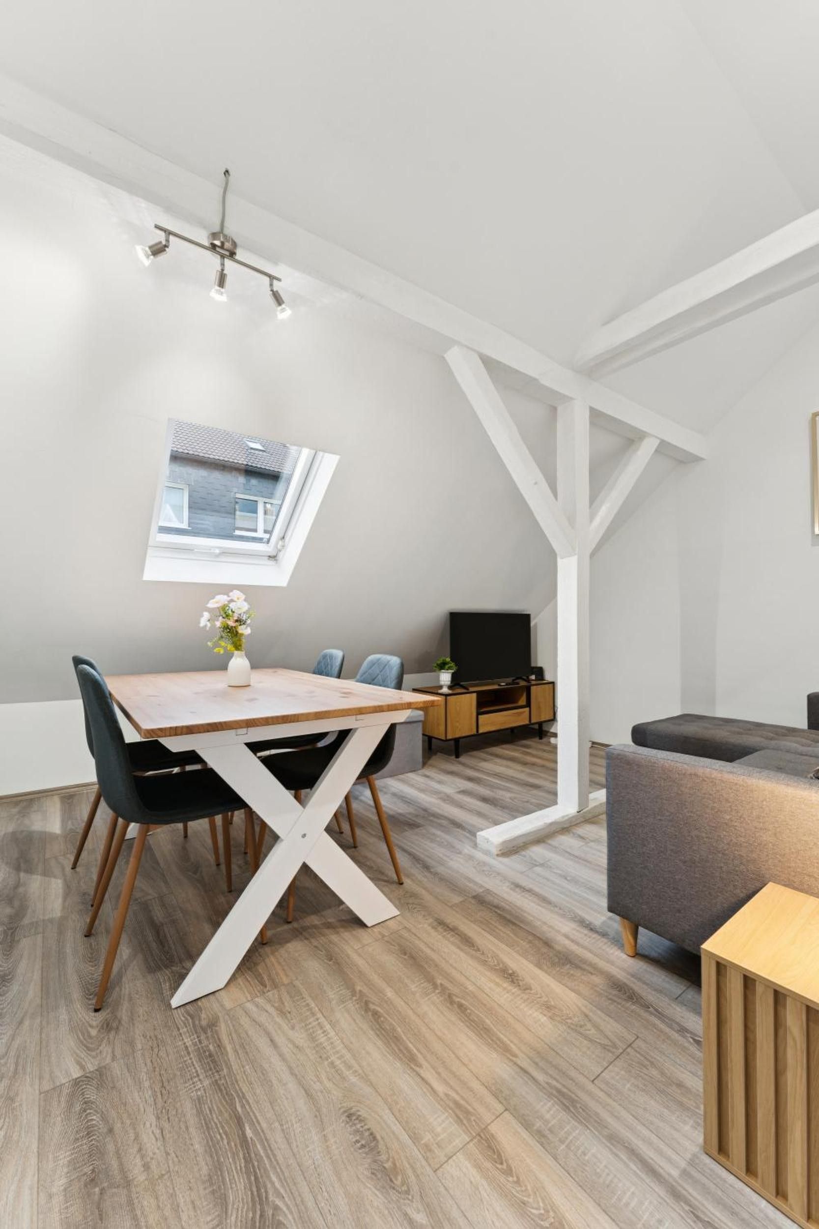 Ein modernes Interieur mit Essbereich, einer Couch und einem Fernseher.