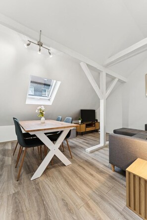 Ein modernes Interieur mit Essbereich, einer Couch und einem Fernseher.