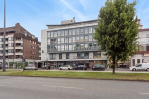 Ein mehrgeschossiges Gebäude mit moderner Fassade, mit einem Ladenlokal im Erdgeschoss, auf dem die Schilder 'Biffar Studio' und 'ParfumKönig' sichtbar sind.