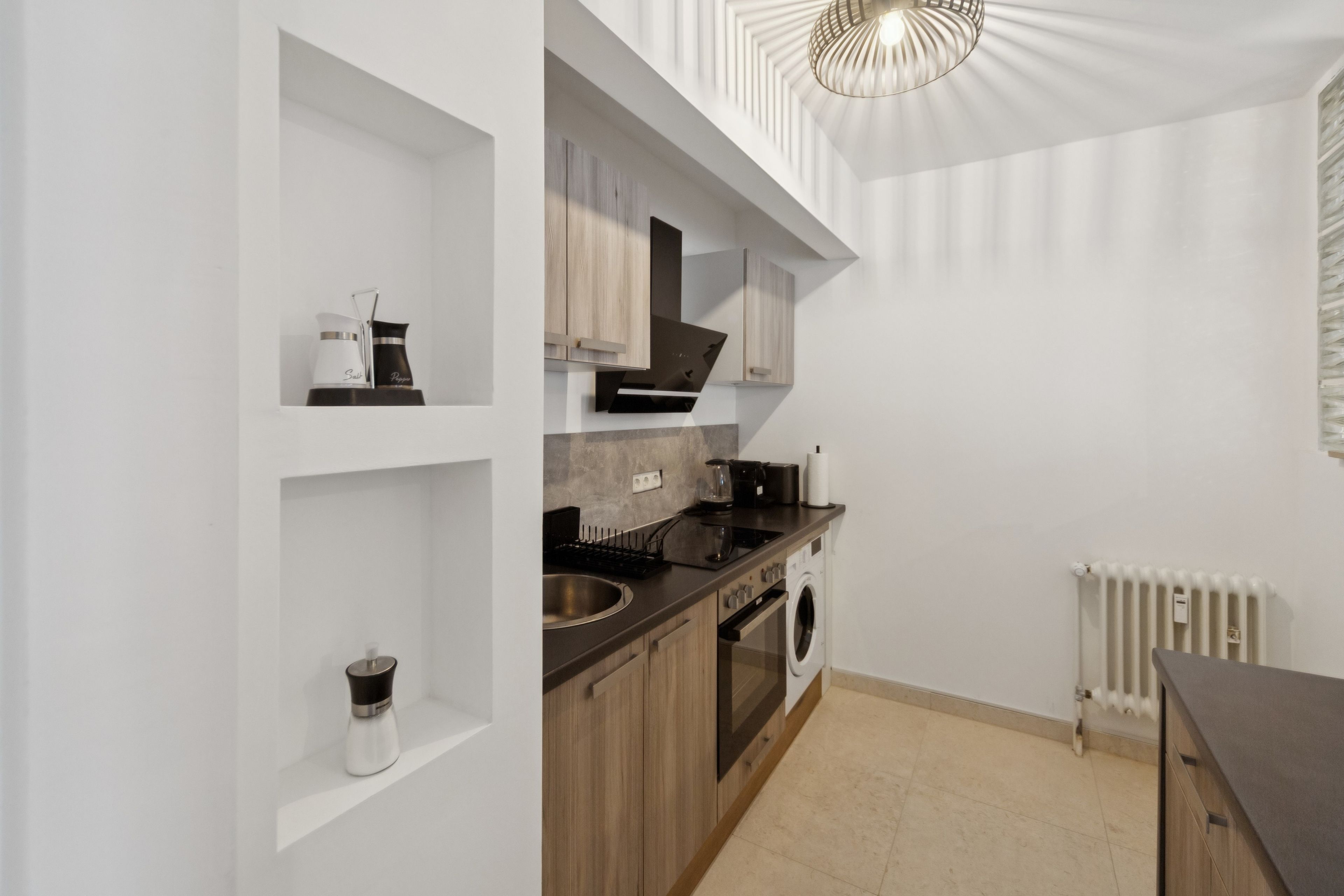 Una cocina moderna con armarios de madera, horno empotrado y pileta.