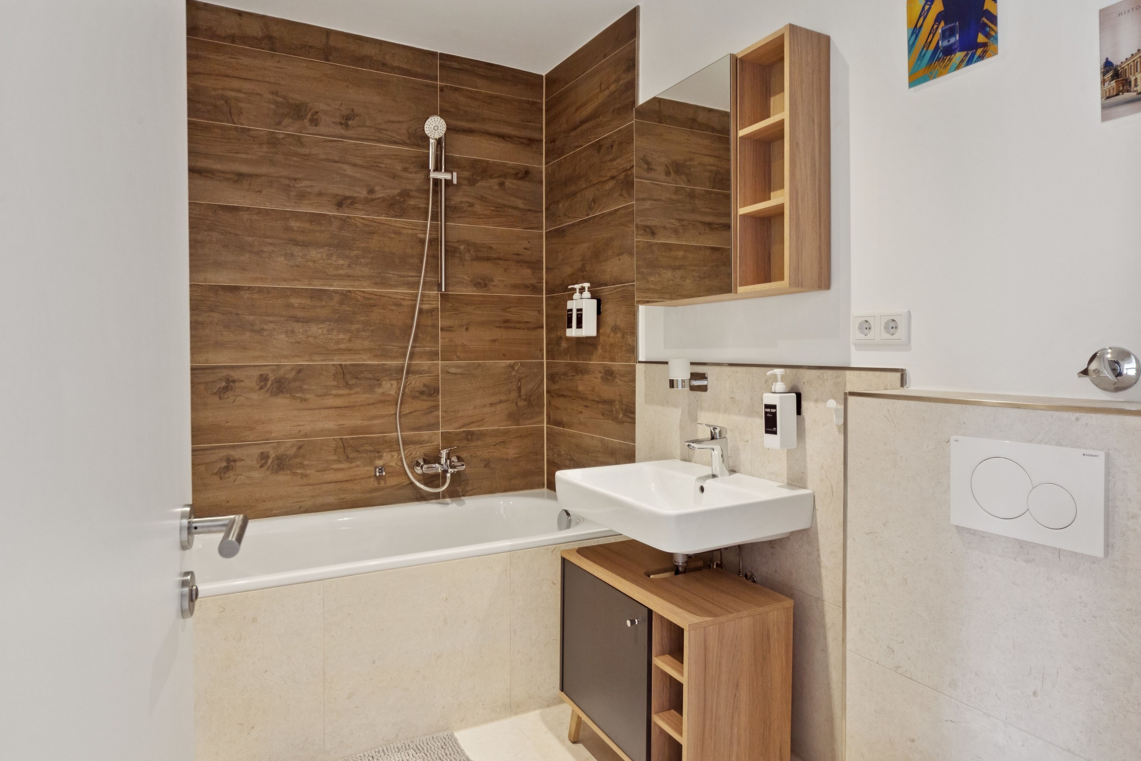 Ein modernes Badezimmer mit Holzvertäfelung, einer Badewanne, einem Waschbecken und einem Spiegel.
