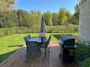 An outdoor patio with a glass-top table, four chairs, a barbecue grill, and an umbrella. - New Listing (Champigny-sur-Veude)