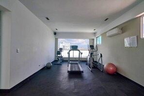 Ein Fitnessraum mit Laufbändern, Crosstrainern und Trainingsbällen.