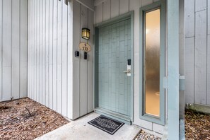 A house with a light blue door, a mailbox, and a doormat with 'WELCOME' written on it. - Tranquil Golf Themed Getaway with Lake View! (Haines City)