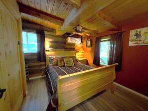 A wooden room with a bed, a ceiling fan, and a window with curtains. - 65 Creekside House | Private Deck On The Water (Sedona)