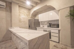 A kitchen with a marble countertop, white cabinets, and a built-in oven. - Luxury 8 Bedroom Mansion in Old City Best Location (Cartagena de Indias)