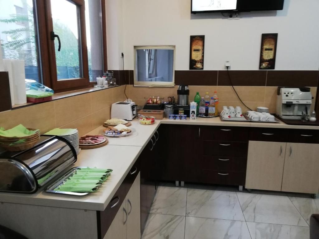 A kitchen with a buffet setup, including a toaster, a coffee machine, and various food items.