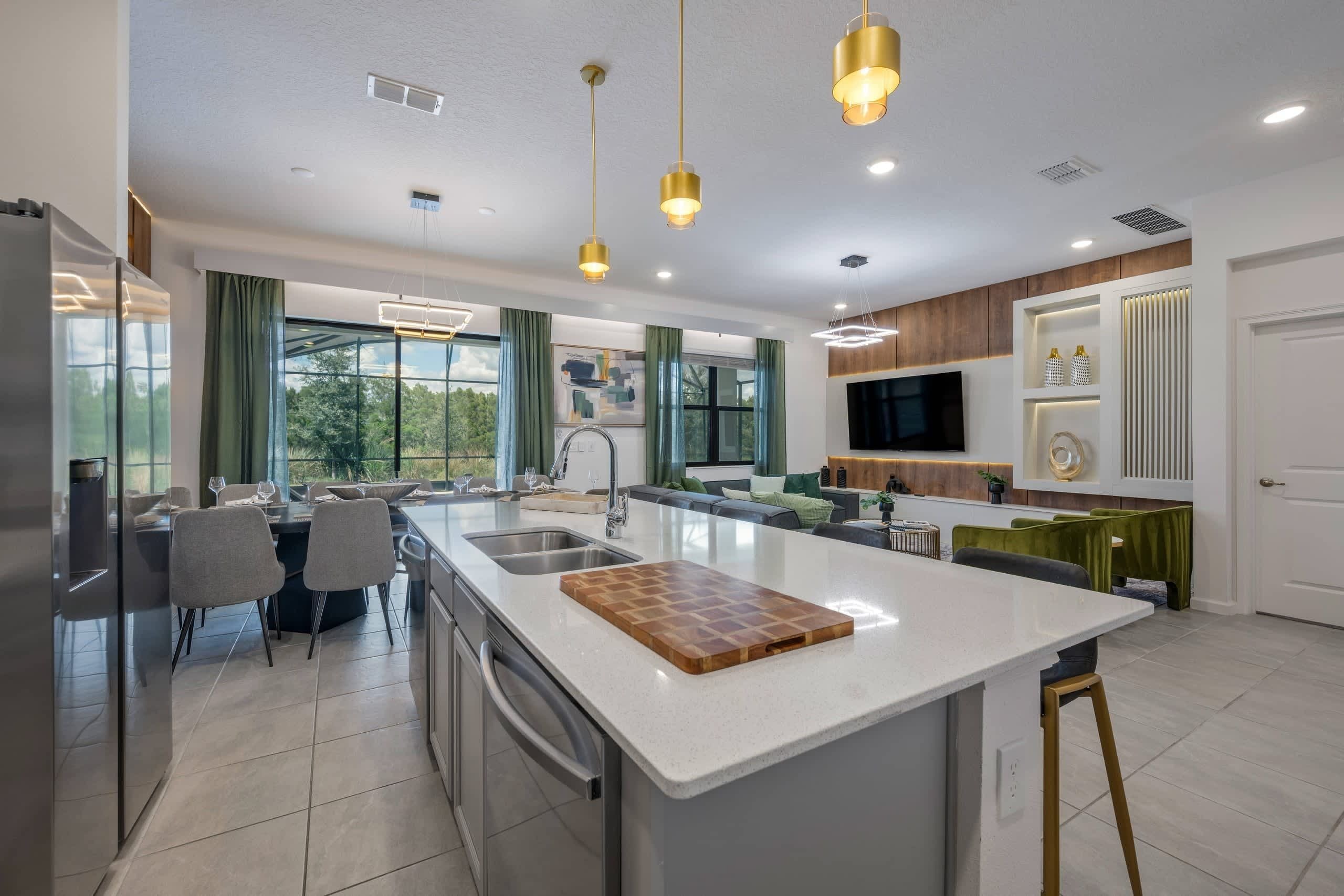 A modern kitchen with a central island, stainless steel appliances, and pendant lighting.