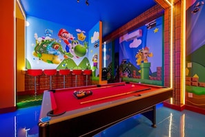 A pool table with a Mario-themed mural in the background. - 8BR Themed Villa Pool, Game Room & Theater (Orlando)