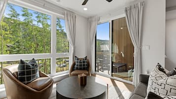A modern living room with a round table, leather chairs, and a sofa.