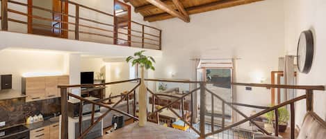 Un intérieur spacieux avec un plafond haut, un coin cuisine, un espace repas et un coin salon offrant une vue agréable.