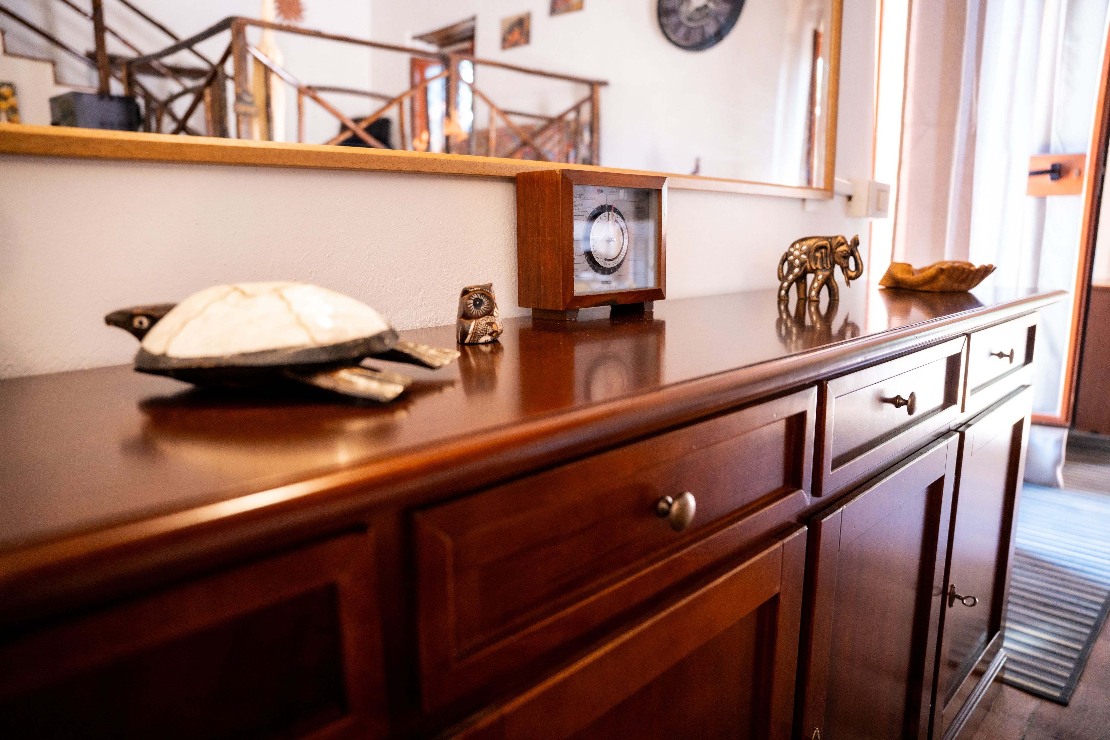 Una encimera de cocina de madera con un reloj, un búho decorativo y una figurita de elefante.