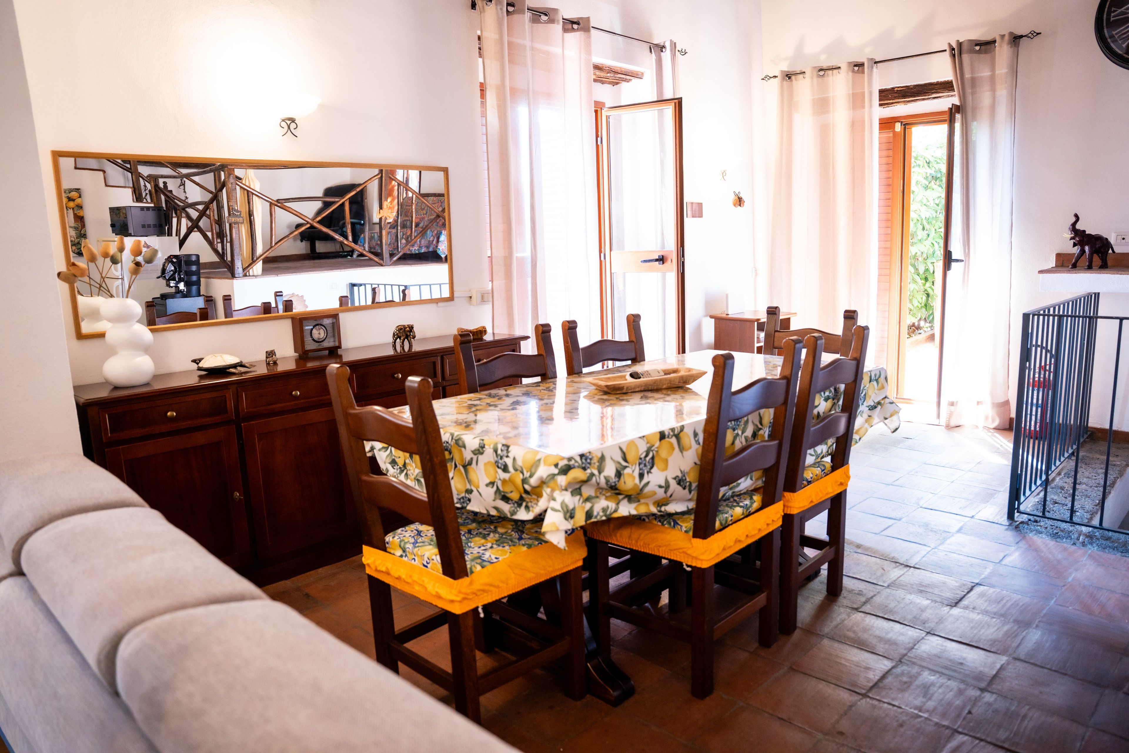 Un coin repas avec une table ronde, des chaises en bois et un miroir au-dessus de la table.