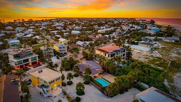 A coastal residential area with houses, a swimming pool, and a beach.