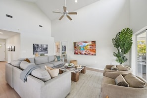 Una sala de estar amplia con un sofá modular, una mesa de centro y una planta grande.