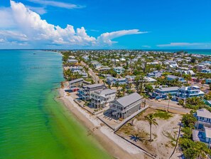 Una zona residencial costera con casas junto a la playa y el océano.