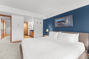 A hotel room with a large bed, a nightstand, a framed picture on the wall, and a view into the bathroom. - D1781-4 (Keystone)