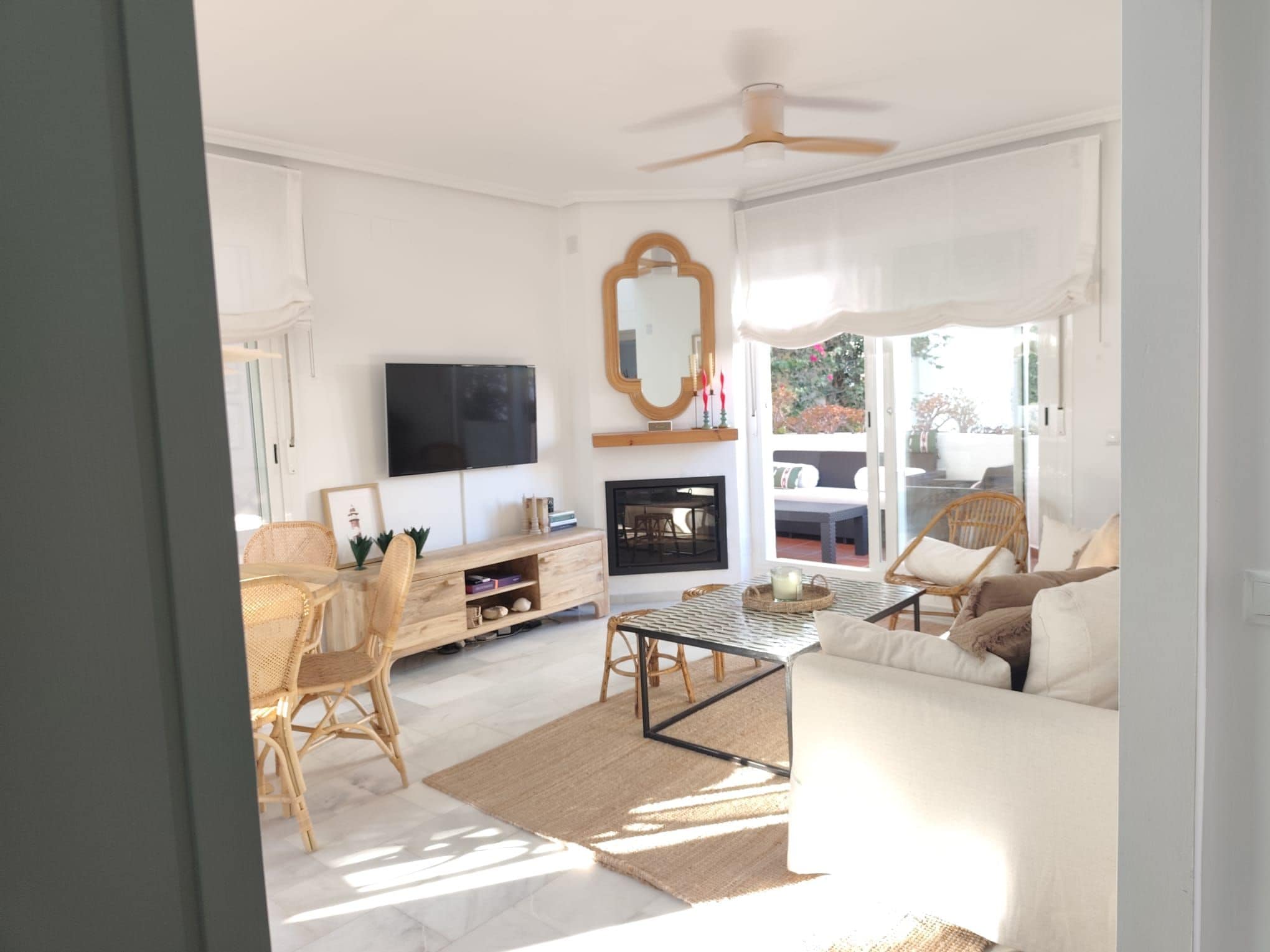 A living room with a sofa, coffee table, and a fireplace.