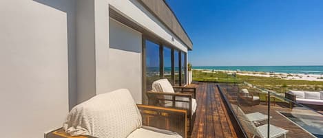 Una terraza moderna al aire libre con vistas a la playa y al océano.