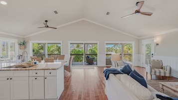 A spacious kitchen with a large island, white cabinetry, and a view to the outside.
