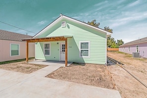 A single-story house with a covered porch, a front door, and a small front yard.