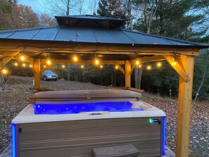 A hot tub under a wooden gazebo with string lights, surrounded by trees. - TheGoodTimes House! Hot Tub+GameRoom+petsok! (Lake Harmony)