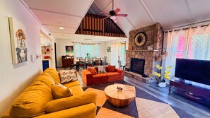 A living room with a sofa, a coffee table, a fireplace, and a television. - TheGoodTimes House! Hot Tub+GameRoom+petsok! (Lake Harmony)