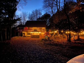 A two-story building with a visible garage and a covered outdoor area. - TheGoodTimes House! Hot Tub+GameRoom+petsok! (Lake Harmony)