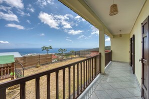 Un balcon avec vue sur la mer et les bâtiments situés au loin.