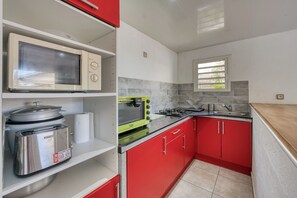 A kitchen with a microwave, toaster, and stove. - Ker Papangue - Terrasse - Wifi (Saint-Louis)