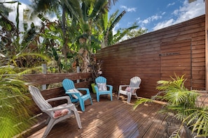 An outdoor deck with wooden flooring, surrounded by a wooden fence, and featuring two Adirondack chairs with cushions. - Ker Papangue - Terrasse - Wifi (Saint-Louis)
