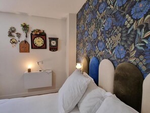 A bedroom with a bed, a wall clock, and a floral tapestry. - House with private pool - 13 guests (Montchal)