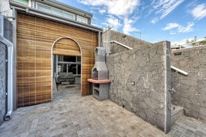 A modern building with a brick exterior, a wooden door, and a stone wall. - Ti'Bulle - Petfriendly - Jacuzzi (Saint-Pierre)
