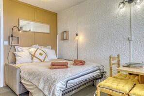 A bedroom with a bed, bedside table, chair, and a mirror on the wall. - Plein Soleil - Balcon - Proche pistes (Hauteluce)