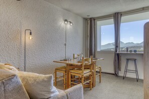 A cozy room with a dining table, chairs, a sofa, a window with a view of mountains, and a floor lamp. - Plein Soleil - Balcon - Proche pistes (Hauteluce)