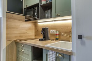 A compact kitchen with a wooden countertop, a coffee machine, a sink, and a set of cabinets. - Plein Soleil - Balcon - Proche pistes (Hauteluce)