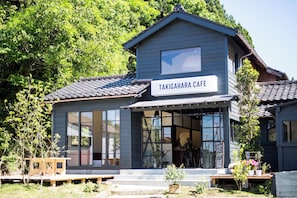 Un edificio de dos pisos con un letrero que dice 'TAKIGAHARA CAFE' en la entrada.